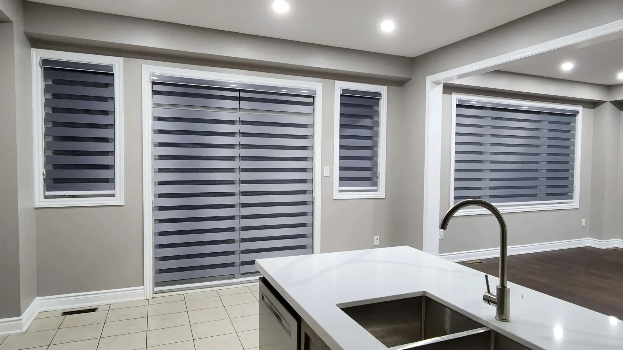 Interior of a modern kitchen with large windows closed with horizontal blinds