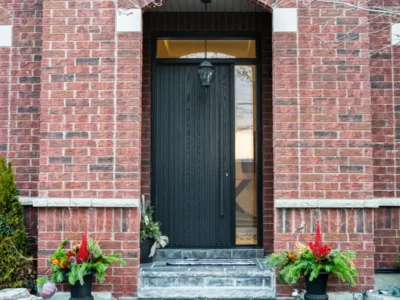 Black entrance door with sidelite in a red brick facade