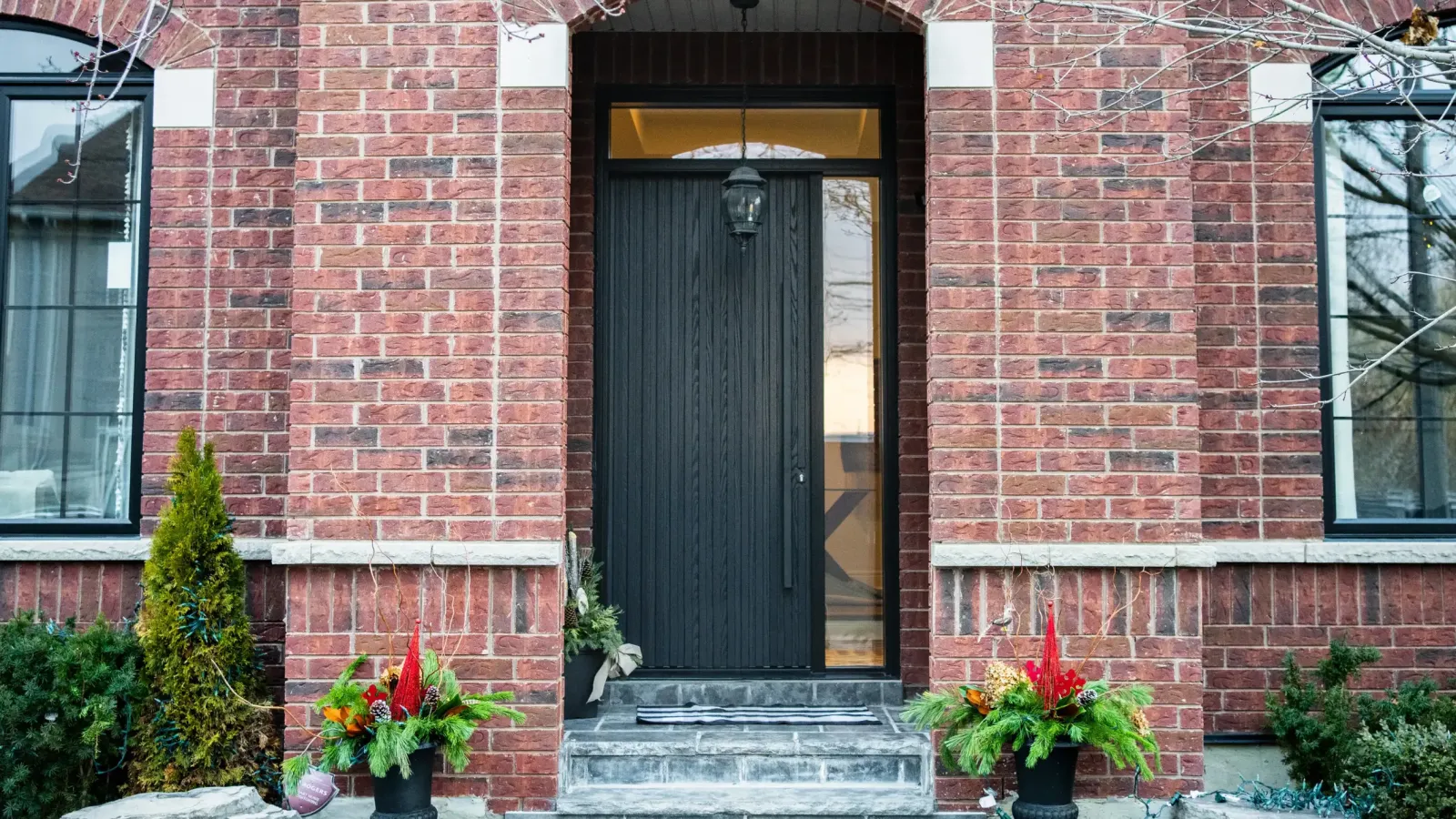 Black entrance door with sidelite in a red brick facade