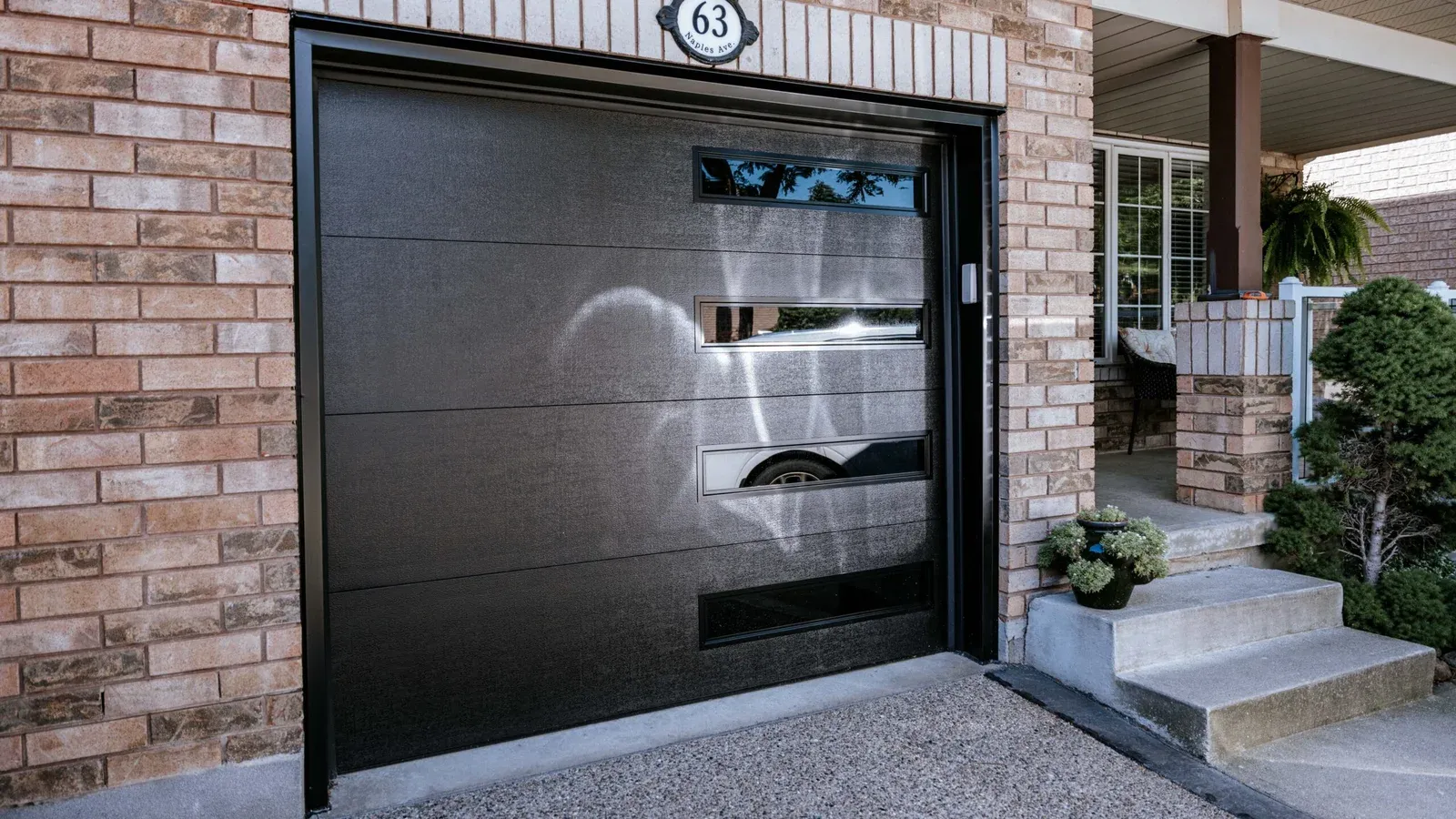 Black insulated garage door with a row of windows