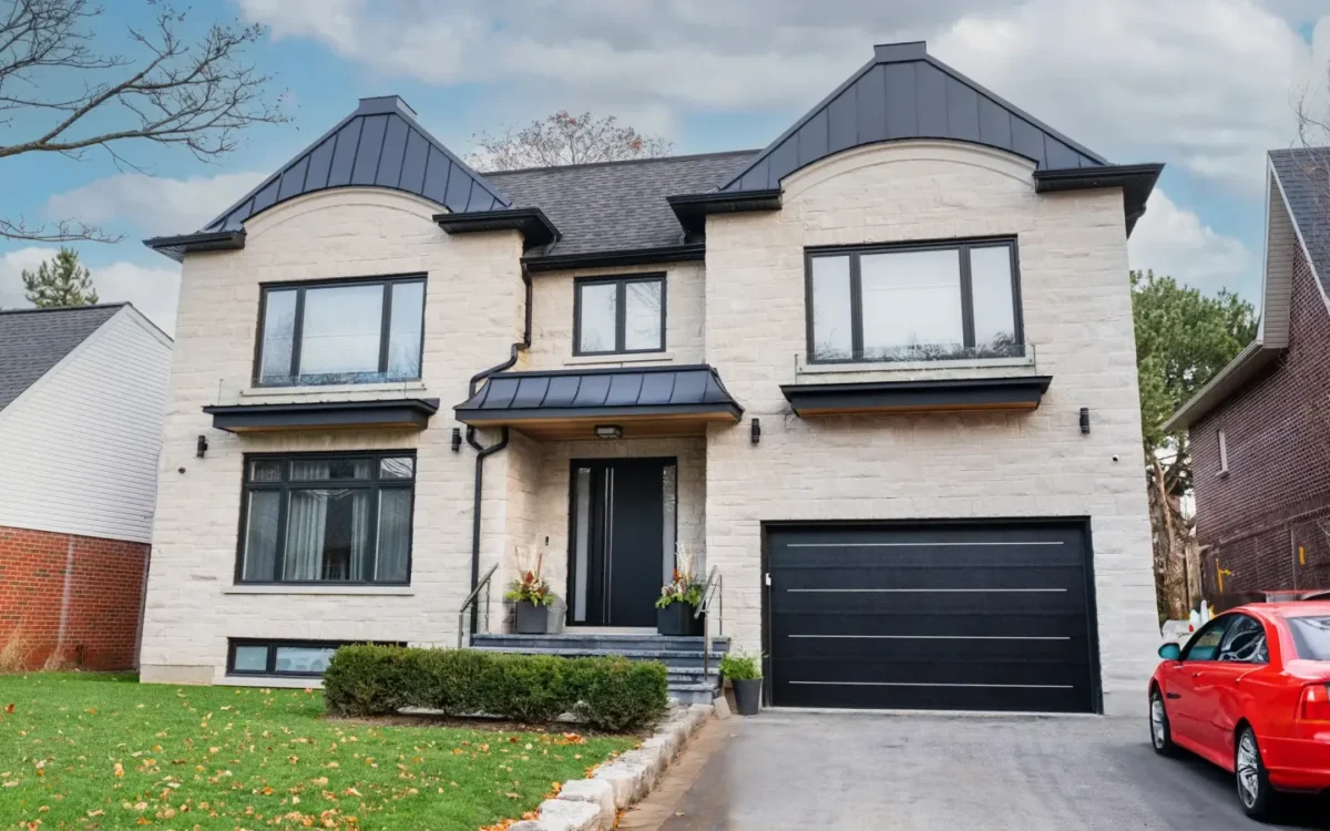 Black garage door on a light stone facade with matching windows