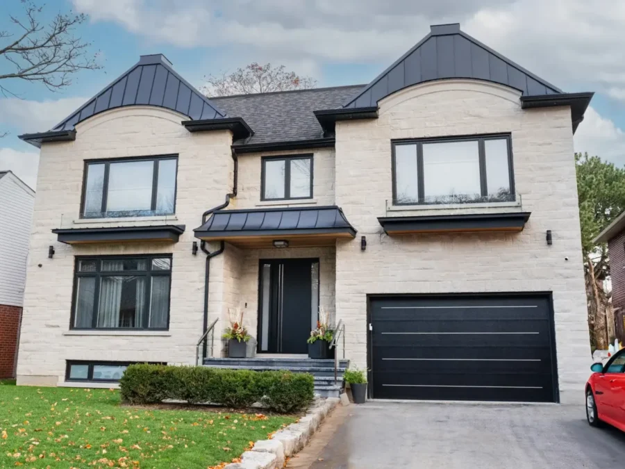 Black garage door on a light stone facade with matching windows