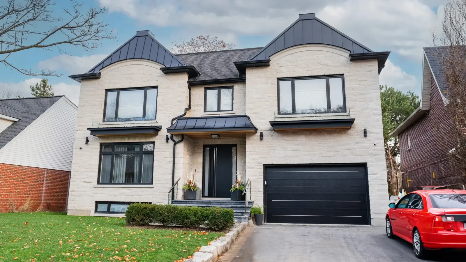 Black garage door on a light stone facade with matching windows
