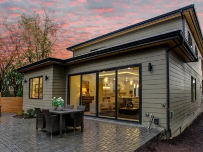 Multi-panel sliding patio door opening onto a paved terrace at dusk