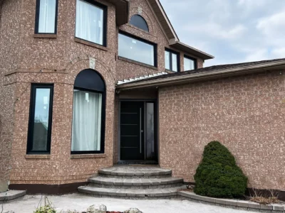 Brick home after full window replacement with black frames