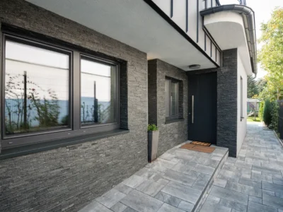 Large black picture window in a stone-clad facade