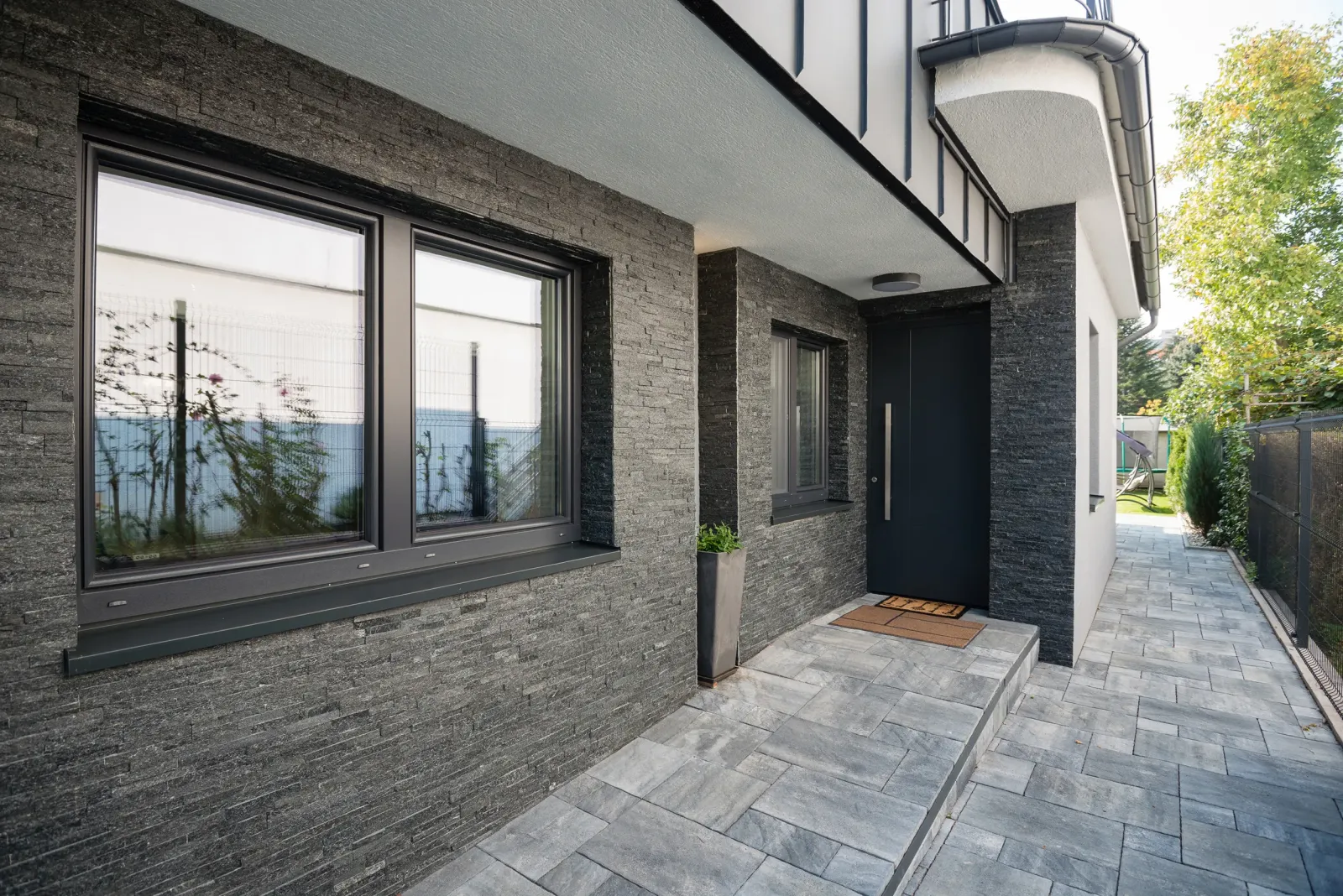 Large black picture window in a stone-clad facade